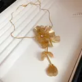 Exquisite close-up of gold hollow wire flower necklace with central rhinestone detail - Hollow Flower Necklace (HN8635) / Gold