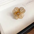 Detailed close-up of a gold hollow floral bracelet with central rhinestone inlay - Hollow Flower Open Ring (HR2533) / Gold