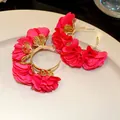 Close-up detail of red chiffon fabric flower C-shaped hoop earrings on a cream ceramic plate - C-Shape Floral Style (HE30814) / Rose Red