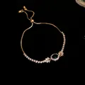Detailansicht eines goldenen Schiebearmbandes mit ovalem grünen Stein und Zirkon-Akzenten - Ovale Anhänger Armband / Gold-Grün