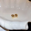 Close-up of golden geometric stud earrings with polished mirror finish on a shell tray - 36# Silver Earring Post - Gold