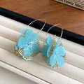 Close-up of blue fabric flower earrings with elegant gold-toned hollow petal design - Flower Style (HE25162) / Light Blue