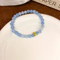 Ethnic style light blue crystal beaded bracelet featuring a decorative textured gold bead - Style 111 (Gold Embossed Decoration) / Blue