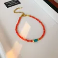 Elegant ethnic style beaded bracelet with translucent orange beads and turquoise accent - Style 120 Bracelet / Gold-Red-Blue