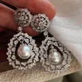 Close-up of sparkling silver-toned earrings with intricate crystal pavé and large central pearls - Palace Flower Pearl Style (13#) / Silver