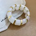Elegant white marbled acrylic stretch bracelet with gold-tone spacers for a modern look - White Marble Pattern