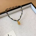 Ethnic style beaded bracelet featuring a gold shell pendant with black and gold seed beads - Shell Pendant Style (148) / Black