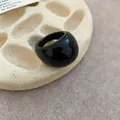 Detailed view of a glossy black resin chunky geometric ring on a minimal display tray - 10# Black
