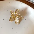 Close-up of a vintage gold-toned floral ring with intricate textured petals on a plate - 43# Gold