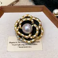 Detailed macro view of an elegant camellia brooch featuring a grey pearl and gold chain - Gold Chain Edging Style (WP158)