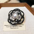 Close-up of a French style houndstooth camellia brooch with a central large pearl. - Houndstooth Style (WP161)
