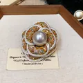 Close-up of a French style camellia brooch with tweed fabric and a central pearl. - Colorful Tweed Style