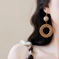 Close-up detail van bohemien geweven rotan oorbellen op een Aziatisch model - Rotan Geweven Hoepelstijl / 3# Stalen oorbelsteker-Koffie-Rond