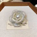 Detailed macro view of an elegant white tweed camellia brooch with pearl edge decoration - Pearl Edged Style