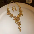 Close-up of vintage floral teardrop crystal necklace and earring set in gold finish - Necklace and Earring Set / Champagne