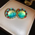 Handmade shimmery green gradient round stud earrings with colorful crystal border detail - Gold-Blue