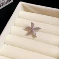 Close-up of a silver-toned metal starfish ear clip on a cream jewelry tray - Spotted Starfish / Silver