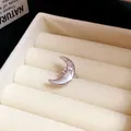Close-up detail of a silver crescent moon ear cuff featuring a vintage facial profile design - Moon / Silver