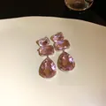 Dettaglio macro di eleganti orecchini in cristallo rosa su un piatto decorativo - Rosa