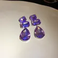 Dettaglio di orecchini di cristallo viola con pietre rettangolari e a forma di goccia. - Viola