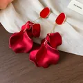 Detail shot of elegant red acrylic flower petal earrings with gold-toned metal accents - Gold / Red