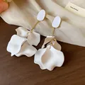 Close-up macro view of elegant white acrylic petal earrings with stylish gold-toned metal accents - Gold / White
