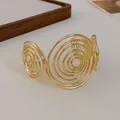 Close-up of golden minimalist spiral open cuff bracelet showing swirl detail - Style 3-Swirl