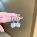 Silver dangle earrings with crystal hoops and white floral pom-pom charms - Style 13