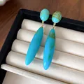 Detalle de pendientes de gota azules vintage con elegante textura acrílica jaspeada. - Verde azulado