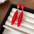Elegantes pendientes de gota vintage rojos en acrílico en una bandeja de joyería - Rojo
