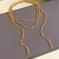 Detailed close-up of an elegant multi-layered gold chain necklace with square metallic accents - Necklace(HN6070) / Gold