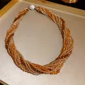 Close-up of bohemian multi-layer twisted crystal beaded bracelet with jeweled clasp. - Necklace / Brown