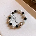 Detailed macro view of geometric contrast beaded jewelry with pearl and silver beads - Silver/Black