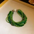 Close-up of bohemian multi-layer green crystal bead bracelet with pavé clasp - Bracelet / Green