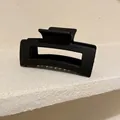 Vista dettagliata di una pinza per capelli nera opaca minimalista su bordo in pietra - Grande Stile Rettangolare (HH1303) / Nero opaco