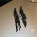 Detailed macro view of elegant black rhinestone tassel drop earrings on a golden surface. - Black Tassel (31#)