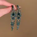 Gros plan sur des boucles d'oreilles pendantes à pompons zircon vert - Style Long de Grappe de Fleurs (2#)
