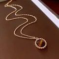 Macro detail of a vintage tiger eye stone pendant on a twisted gold necklace chain. - Style 40 / Gold Brown