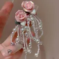 Close-up of pink flower earrings with pearl bead tassels and crystal accents - Style 8 / Pink