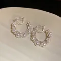 Vue détaillée de boucles d'oreilles clips en C torsadées avec perles élégantes et pierres pavées - Boucles d'oreilles à clip / Argent