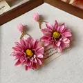 Detailed view of pink raffia flower earrings with delicate yellow stamen - Pink