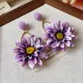 Detailed macro view of purple fabric flower earrings with yellow centers for vacation - Purple