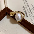 Close-up of a vintage gold plated open ring with a large oval baroque pearl detail - Adjustable (HR1905) / Gold