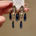 Elegante Vintage-Quastenohrringe mit blauen Kristallen und antikgoldener Oberfläche. - Silberne Nadel Stil (30)
