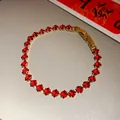 Detail view of gold-plated bracelet featuring square-cut red cubic zirconia stones - Red-Rhombus