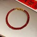 Close-up detail showing a vintage red zircon square clasp bracelet in gold finish. - Red-Square