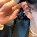 Detailed view of clear zircon ear cuff featuring a stylish vintage floral cross pendant - Single Right Ear / Silver