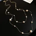 Macro view of French vintage double-layer necklace featuring asymmetrical white pearls. - Double Layer Necklace / Gold-White