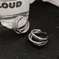 Close-up of silver triple-layered metal hoop earrings with a minimalist cool style - Style 1 / Silver
