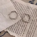 Detailed view of silver twisted double hoop earrings on aesthetic paper background - Style 3 / Silver
